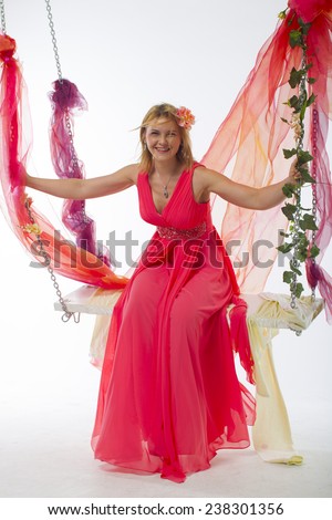 https://thumb9.shutterstock.com/display_pic_with_logo/1796744/238301356/stock-photo-beautiful-young-woman-on-a-swing-in-a-bright-pink-salmon-color-long-dress-with-flowers-in-her-238301356.jpg