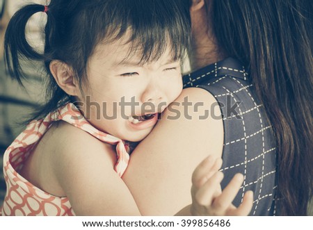 Asian baby girl hugging her mother crying