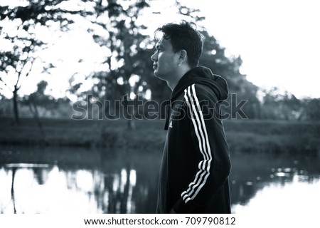 NAKHON PATHOM, THAILAND - SEPTEMBER 2, 2017:A man wear adidas sports jacket and sweatpants, A German multinational corporation that designs and