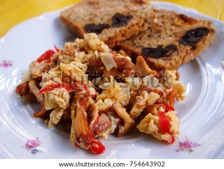 Scrambled Eggs With Chanterelle Mushrooms Onion And Tomatoes Served Toasted Whole Grains Bread Mixed