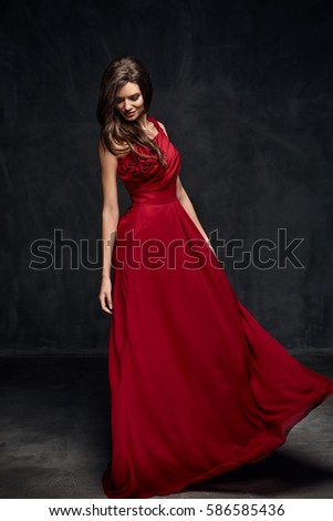 stock photo beautiful young model female with dark hair in long red dress standing in dark studio 586585436