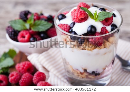 yogurt with muesli and berries on a wooden table