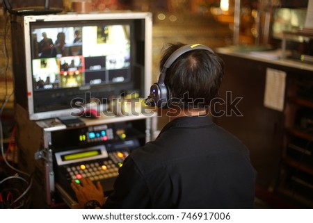 Director working on the video or media switcher to edit and broadcast video.