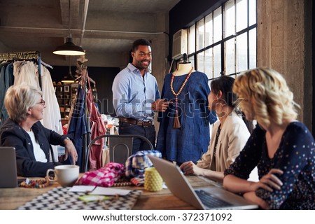 Four Fashion Designers In Meeting Discussing Garment