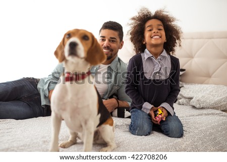 Cute little african american girl playing with her dog.