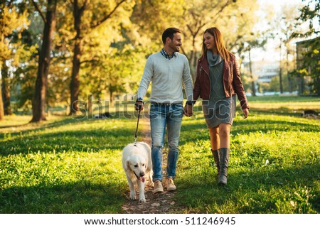 https://thumb9.shutterstock.com/display_pic_with_logo/1927106/511246945/stock-photo-couple-walking-the-dog-together-in-the-park-511246945.jpg