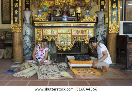 Bac Ninh, Vietnam - Sep 12, 2015: Senior craftsmen making printed painting artwork in traditional way in Dong Ho village. Famous Dong Ho paintings has become aesthetic symbol of Vietnamese culture.