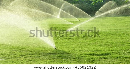Irrigation System Watering the green grass, blurred background