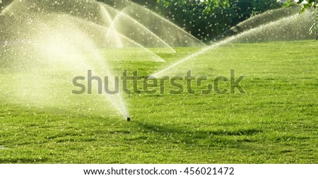 Irrigation System Watering the green grass with bokeh background
