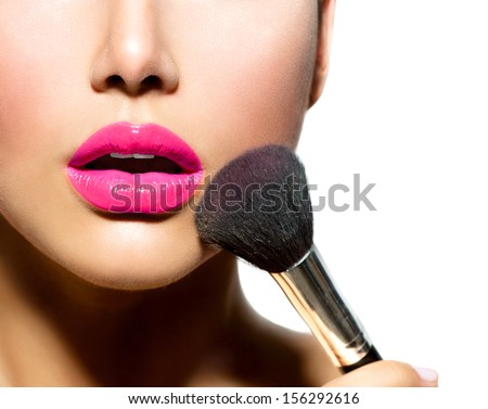 Makeup. Make-up Applying closeup. Cosmetic Powder Brush for Make up. Perfect Skin. Purple Lipstick. Isolated on a White Background. Makeover