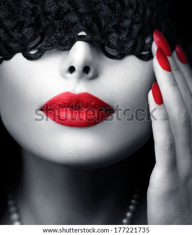 Beautiful woman with black lace mask over her eyes red sexy lips and nails closeup Beautiful woman with black lace mask over her eyes red sexy lips and nails closeup