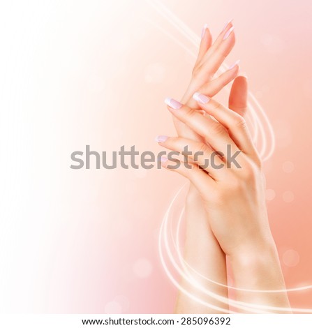 Beautiful Healthy Female Hands. Spa and Manicure concept. Woman hands with french manicure. Soft skin, skincare concept. Beauty nails. over beige background
