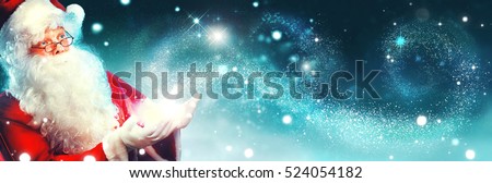 Santa Claus with magic gift in his hands. Portrait of happy Santa Claus making magic at night, Blowing Magic Christmas Stars