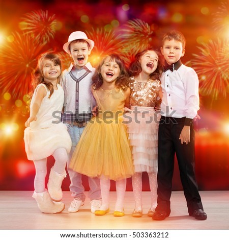 Group of happy kids in holiday clothes with fireworks on background. Holidays, christmas, new year, xmas, friendship, birthday, fashion concept.