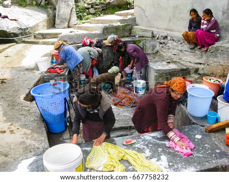 VASISHTA VILLAGE, CITY OF MANALY, STATE HIMACHAL PRADESH, INDIA - APRIL 18, 2014: Women wash clothes at the source. in a small village in the Himalayas in the north of the state Himachal Pradesh.