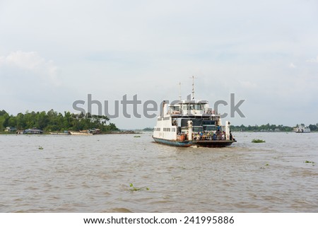 An Giang, Vietnam - Nov 29, 2014: Wide view of river scenery with a ferry boat carries people across Tien river in Mekong delta, southern Vietnam