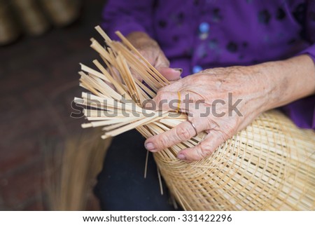 Woman hand weaving tropical bamboo fish trap in traditional crafts village in Vietnam