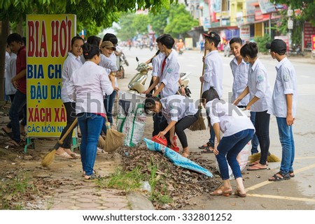 Bac Ninh, Vietnam - Sep 9, 2015: Group of high school students cleaning street in front of their school within the volunteer event for saving environment