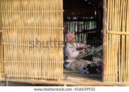 Kon Tum, Vietnam - Mar 28, 2016: Bahnar woman weaves clothing inside of her house in Kon Kotu village, 5km from Kon Tum city