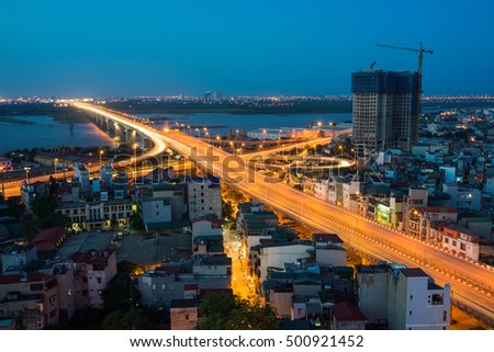 Aerial view of Hanoi cityscape at twilight. Vinh Tuy bridge crossing Red River.