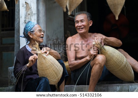 Hung Yen, Vietnam - July 9, 2016: Couple craftsmen making traditional bamboo fish trap at her old house in Thu Sy trade village