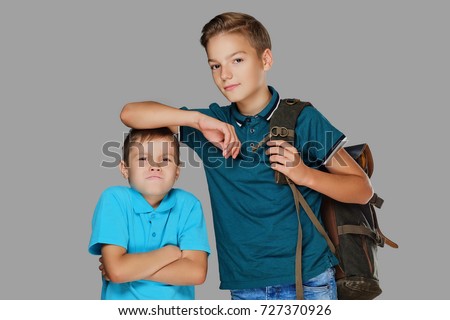 stock-photo-a-tall-teenage-boy-put-his-arm-on-the-head-of-an-angry-small-boy-727370926.jpg