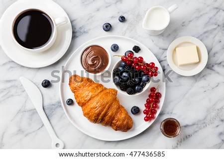 Croissant With Fresh Berries Chocolate Spread And Butter Cup Of Coffee On A Marble Croissant With Fresh Berries Chocolate Spread And Butter Cup Of Coffee On A Marble