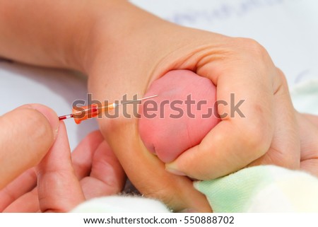 Midwife take blood sample from a newborn during metabolic screening Midwife take blood sample from a newborn during metabolic screening