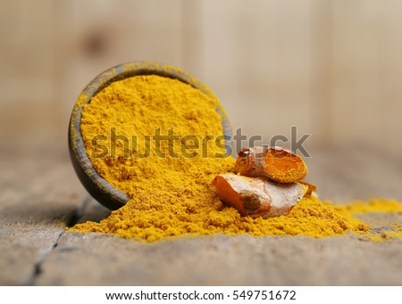 Turmeric powder on wooden background.