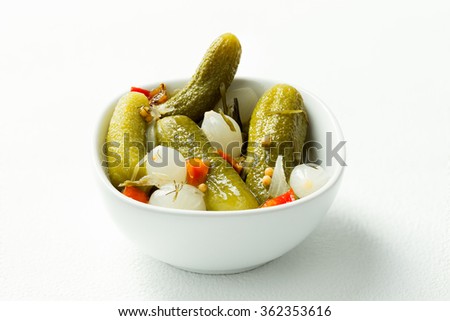 pickled cucumbers and onions with vinegar and pepper in white bowl