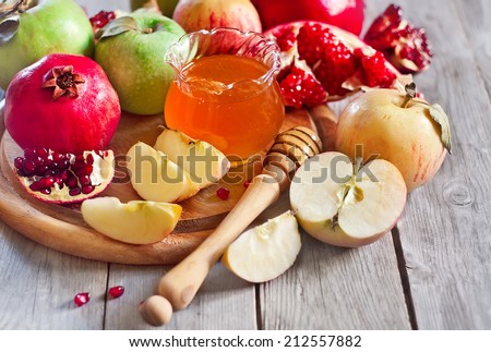 Pomegranate, apple and honey, traditional food of jewish New Year celebration, Rosh Hashana. Selective focus.