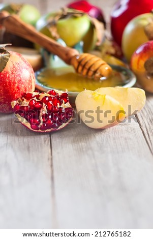 Pomegranate, apple and honey, traditional food of jewish New Year celebration, Rosh Hashana. Selective focus. Copyspace background