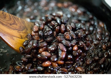 Handmade black beans, simmered with sugar and soy sauce. Boiled beans in black iron pan.