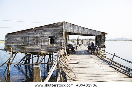 Phu Yen, Vietnam - Mar 31, 2016: Ong Cop bridge ( Mr Tiger 's wooden bridge), the longest wooden bridge in Vietnam. A woman cycling on the bridge