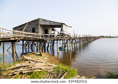 Phu Yen, Vietnam - Mar 31, 2016: Ong Cop bridge ( Mr Tiger 's wooden bridge), the longest wooden bridge in Vietnam. A woman cycling on the bridge