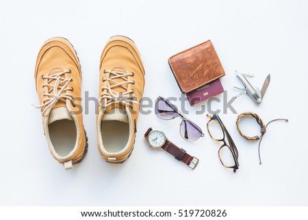 Men's casual outfits with brown shoes and passport, travel preparations and accessories on white background