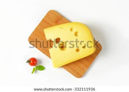 slice of fresh cheese on wooden cutting board