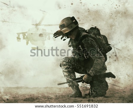 US soldier in the desert during the military operation turning to combat helicopter approaching covering his eyes. Backup is coming