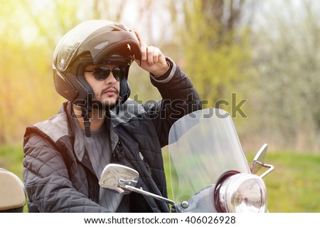 View of a man on the motorcycle with a helmet on.Lens flare