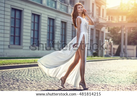 https://thumb9.shutterstock.com/display_pic_with_logo/2429303/481814215/stock-photo-beautiful-elegant-woman-in-long-white-flattering-dress-walking-on-the-street-481814215.jpg