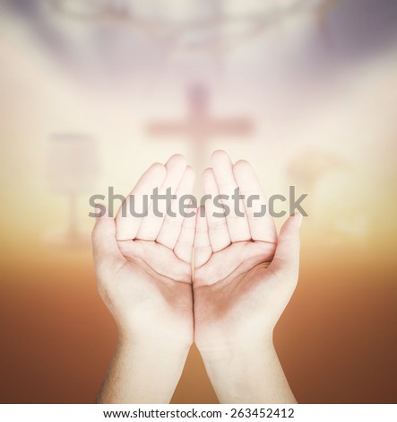 Hands of man praying over blurred glass of wine and Loaf of bread with ...