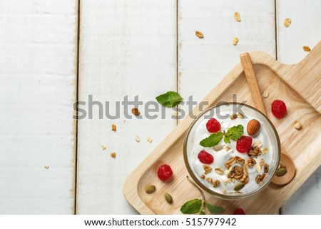 Homemade yogurt or sour cream in a glass on the white wooden table