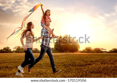 stock-photo-family-running-through-field-letting-kite-fly-570119506.jpg