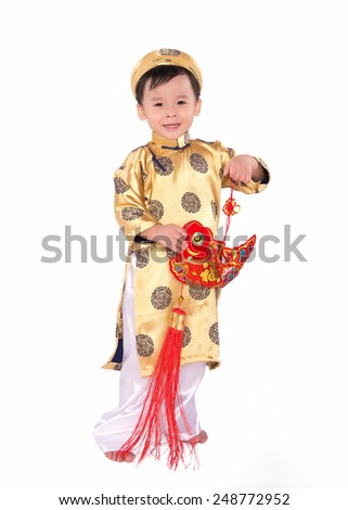 Vietnamese boy cuddling stuffed carp. Portrait of a handsome Asian baby boy on traditional festival costume. Cute little Vietnamese boy in ao dai dress smiling.