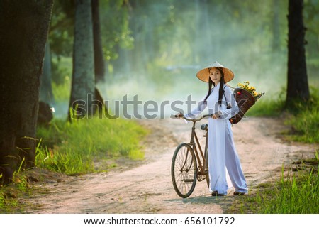 beautiful woman with Vietnam culture traditional dress, Ao dai and riding bicycle