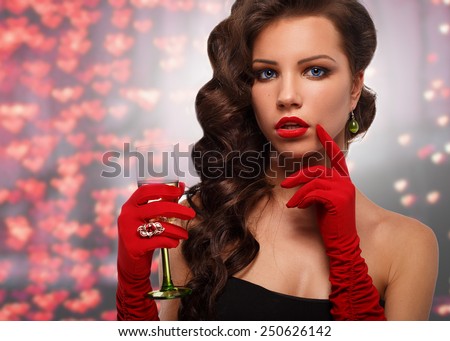 Glamour girl in red gloves holding a glass of champagne. drinking champagne. Beauty woman with perfect fashion makeup.congratulations on Valentine's Day