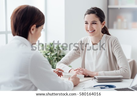 Smiling patient in the doctor's office, she is receiving a prescription medicine