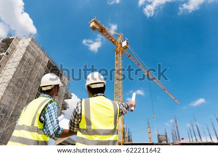 Construction engineers discussion with architects at construction site or building site of highrise building
