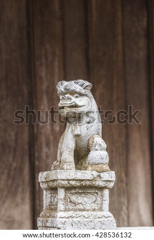BAC NINH, VIETNAM - JULY 25, 2015 - Small statue at the entrance to But Thap Pagoda with a demon or lion on a decorated pedestal with a flower motif