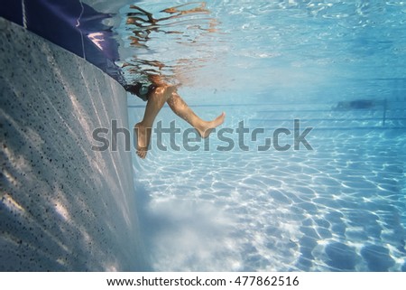 Child's feet in water on side of pool